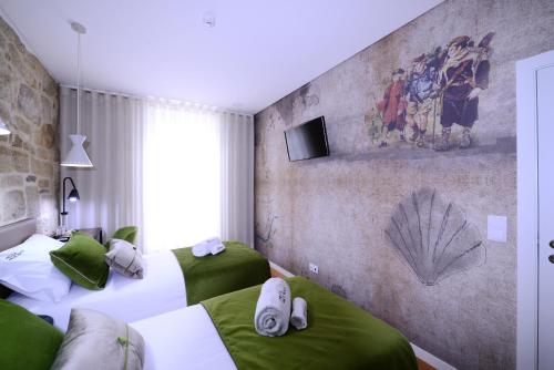 two beds in a room with green and white at VILA DE PONTE GUEST HOUSE in Ponte de Lima
