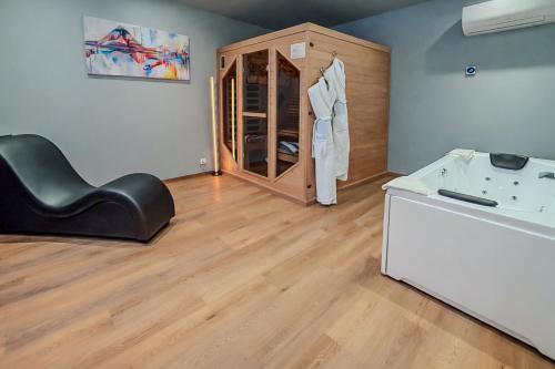 a salon with a black leather chair and a sink at Tulip Inn Honfleur Residence & Spa in Honfleur