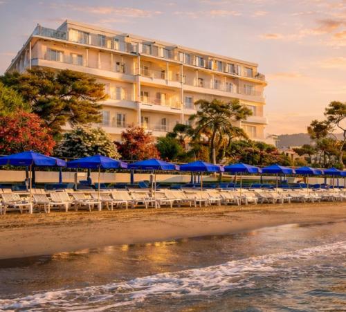 a hotel on the beach with chairs and umbrellas at LVG Hotel Collection - Grand Hotel Mediterranee in Alassio