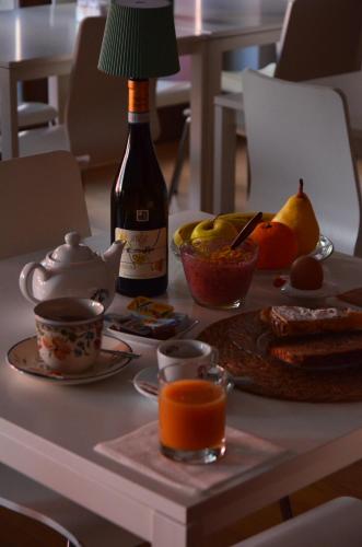 a bottle of wine sitting on a table with food and fruit at Tenuta Roletto Cascina Guie in Cuceglio
