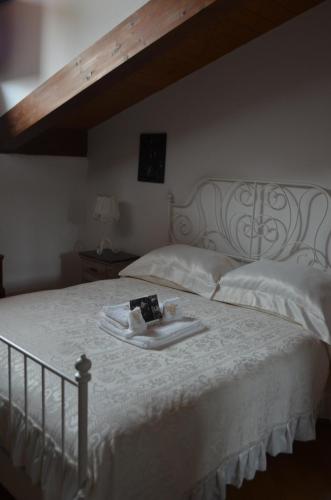 a white bed with a tray with a book on it at Tenuta Roletto Cascina Guie in Cuceglio