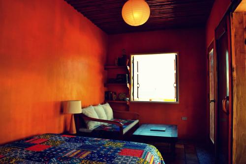 a red bedroom with a bed and a window at Guerrera Rice Paddy Villas in Mambajao