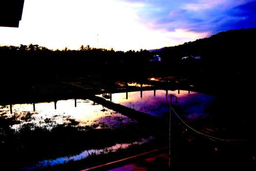 a reflection of the sky in a body of water at Guerrera Rice Paddy Villas in Mambajao