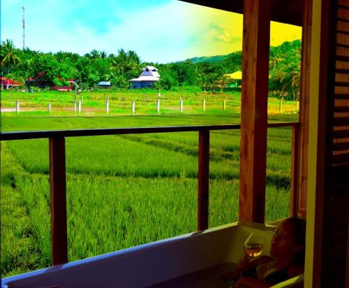 a window with a view of a green field at Guerrera Rice Paddy Villas in Mambajao