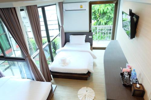 a bedroom with two beds and a balcony at A Plus Deluxe Hotel in Ko Lipe