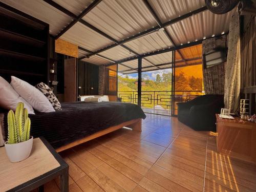 a bedroom with a bed and a large window at Cabañas Ecologe BLESS in Chiquinquirá