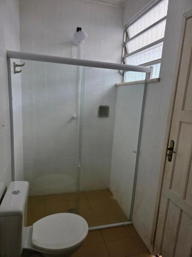 a bathroom with a shower with a toilet and a glass door at Quarto Ametista in Aracaju