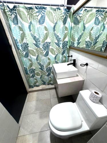 a bathroom with a toilet and a sink at Adhoc Cintermex in Monterrey
