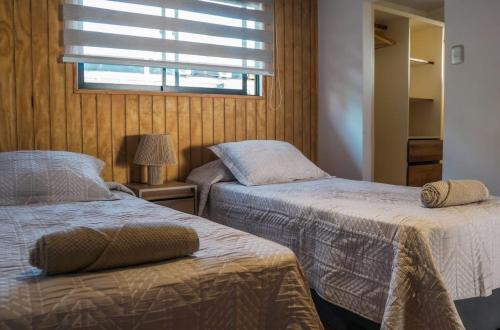 two beds in a room with a window and a bed sidx sidx sidx at Te Manu Lodge in Hanga Roa