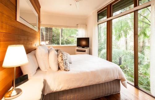 ein Schlafzimmer mit einem großen Bett und einem Fenster in der Unterkunft Cottage in the Forest in Olinda