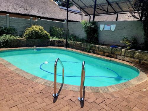 a small swimming pool with two metal bars around it at Sandstone Escape Guesthouse in Ladybrand