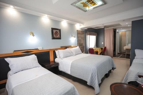 a hotel room with two beds and a table at Hotel A&B Internacional in Buenos Aires