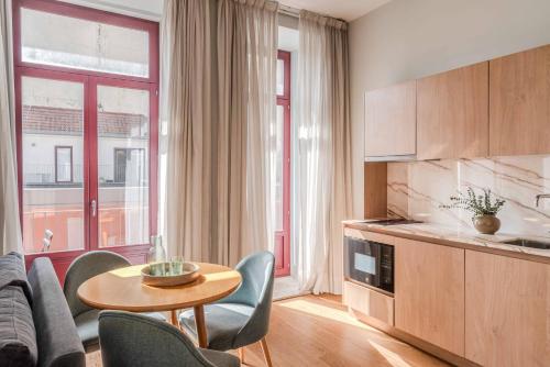 a living room with a table and chairs and a kitchen at Uma Formosa Apartments in Porto