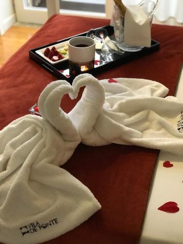 a table with towels in the shape of a heart at VILA DE PONTE GUEST HOUSE in Ponte de Lima