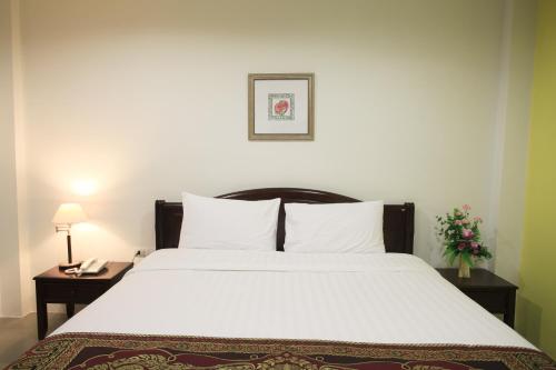sypialnia z dużym białym łóżkiem z 2 stolikami nocnymi w obiekcie SU 22 w mieście Bangkok