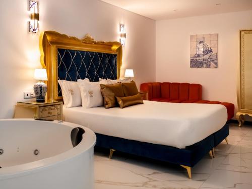 a bedroom with a large bed and a bath tub at Solar Antigo Luxury Porto Aeroporto in Moreira