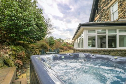 a hot tub in the backyard of a house at Beaumont Exquisite Lakeland House, Sleeps 10 in Windermere