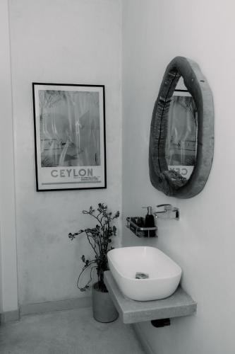a bathroom with a white sink and a mirror at Cafe San-Khara in Ahangama