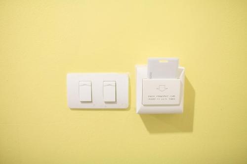 a couple of electrical switches on a yellow wall at SU 22 in Bangkok