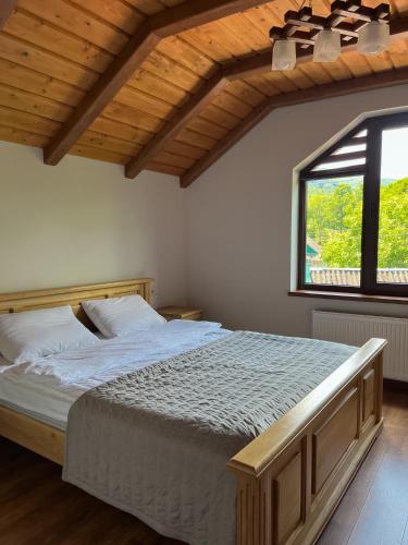 a bedroom with a large bed and a window at Gray house in Yaremche