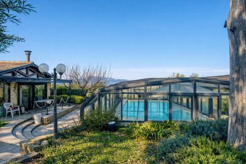 a glass house with a swimming pool at Villa Fefa by MMega in Tolentino
