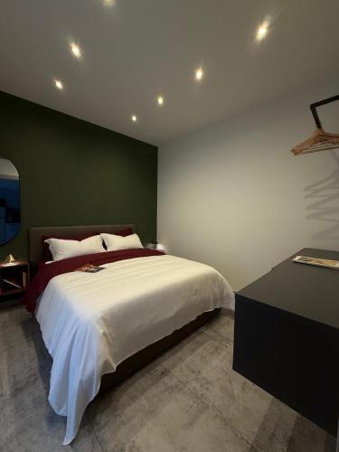 a bedroom with a large bed with a green wall at R Apartment - Venaria in Venaria Reale