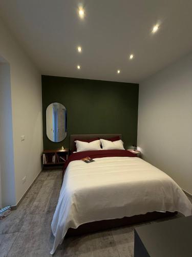 a bedroom with a large bed with a green wall at R Apartment - Venaria in Venaria Reale