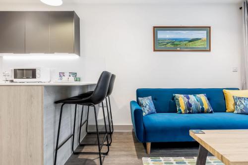 a living room with a blue couch and a table at Once Upon a Tide - Stylish Apartment in the Heart of Poole in Poole