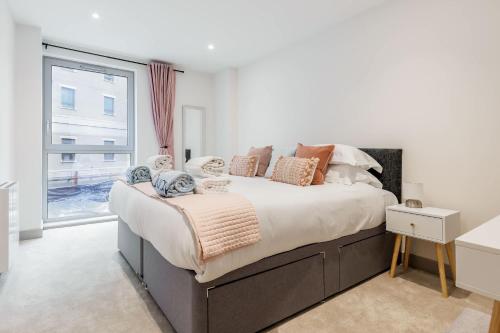 a bedroom with a large bed and a window at Once Upon a Tide - Stylish Apartment in the Heart of Poole in Poole