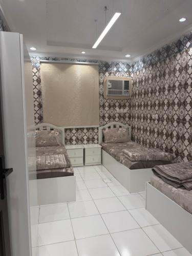 a bedroom with two beds and a mirror at النبلاء in Medina