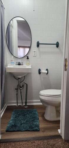 a bathroom with a sink and a toilet and a mirror at #7 Kipling Cottages Last Resort on Lake Michigan in Gladstone