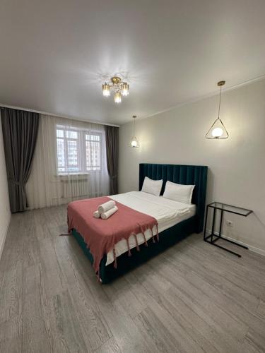 a bedroom with a large bed with a red blanket at Аблайхана 1 г in Kokshetau