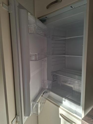 an empty refrigerator with its door open in a room at Apartments AlpRoza in Zgornje Gorje