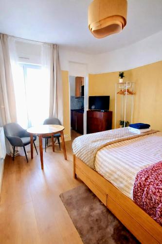 a bedroom with a bed and a table and chairs at Charming Getaway Near Paris in Alfortville