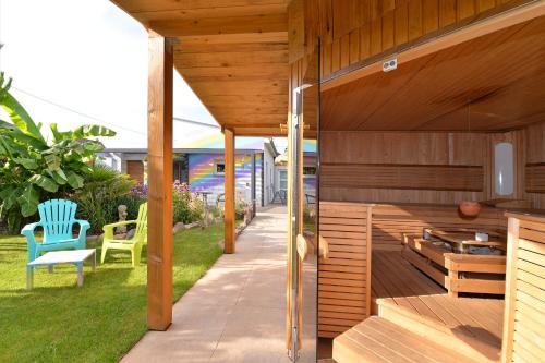 a wooden deck with a blue chair on the grass at Gîte privatif avec spa, sauna à Colmar in Logelbach