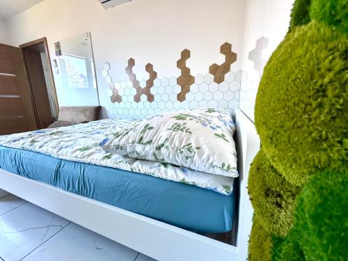 a bedroom with a bed with blue and white sheets at BioKompas SPA Apartment in Wrocław