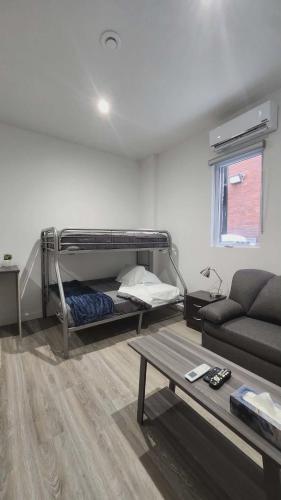 ein Wohnzimmer mit einem Etagenbett und einer Couch in der Unterkunft La Baraque in Thetford Mines