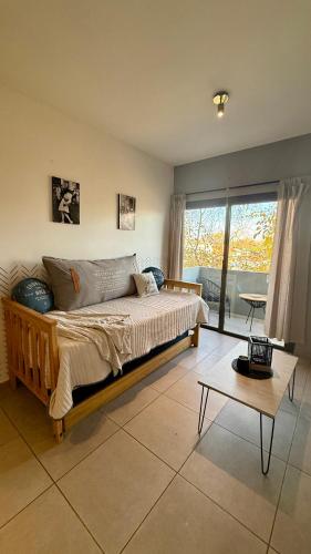 a bedroom with a large bed and a table at Pellegrini Apartments Mendoza !! Estupendos Departamentos con Cochera Privada cercanos a Parque Gral San Martin in Mendoza