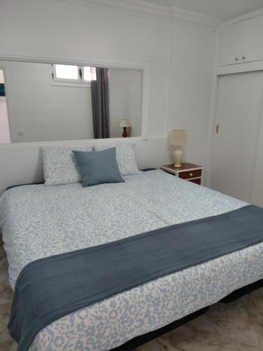a bedroom with a large bed with a blue blanket at Sun and ocean in San Bartolomé