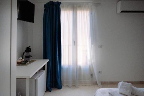 a room with a large window with blue curtains at La Quiete in Scilla