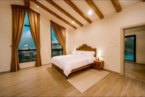 a bedroom with a bed and large windows at 伴山一墅 in Chaoyang