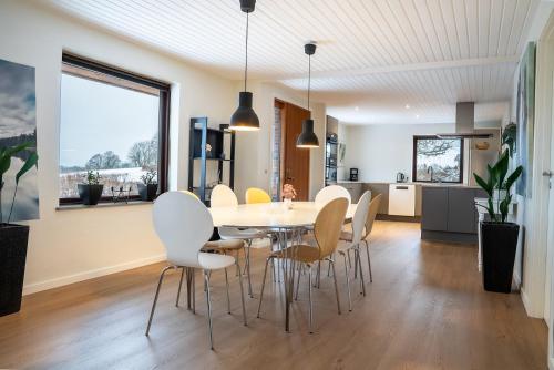 a kitchen and dining room with a table and chairs at Country View Village House near Lake 6 persons in Østbirk