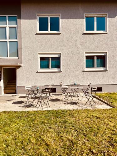 a group of tables and chairs in front of a building at Apartments Yvonne Sigg in Rust