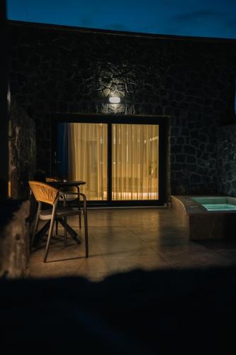 a patio with a table and a chair and a window at Santorini Cave Luxury Suites in Fira
