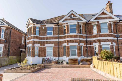 a brick house with a patio in front of it at Park Lake View - Poole Park Lake Views in Poole