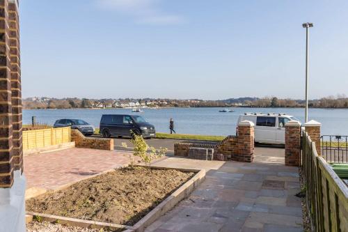 a parking lot with cars parked next to a body of water at Park Lake View - Poole Park Lake Views in Poole