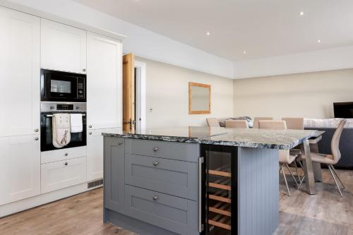 a kitchen with a island with a counter top at Park Lake View - Poole Park Lake Views in Poole