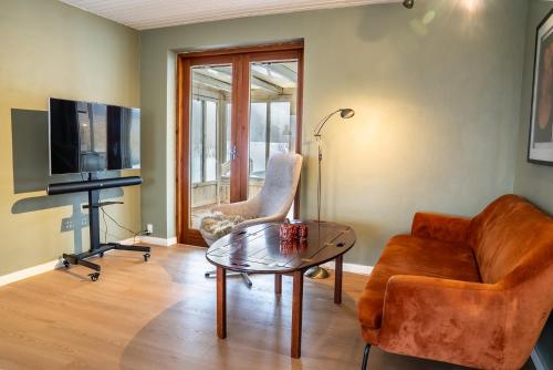 a living room with a couch and a table at Country View Village House near Lake 6 persons in Østbirk