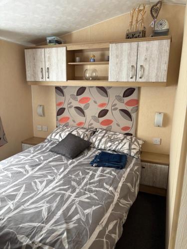a bedroom with a bed with a blanket and pillows at Sleeps 8 guests lovely 3 Bedroom Golden Gate Towyn in Llanddulas