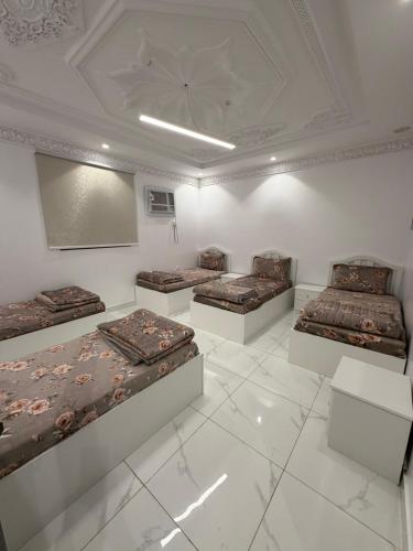 a room with four beds and a screen on the wall at رفاه in Medina